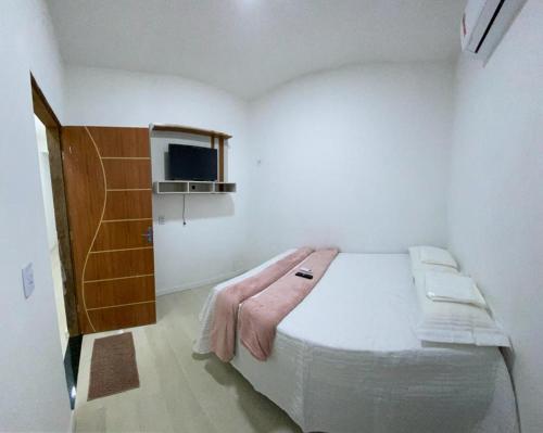 um quarto com uma cama grande num quarto branco em Alemanha aconchego em São Luís
