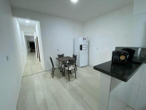 a room with a table and chairs and a refrigerator at Alemanha aconchego in São Luís