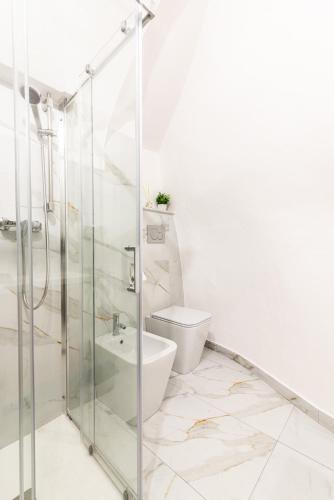 a bathroom with a glass shower and a toilet at Dimora Bianca in Catania