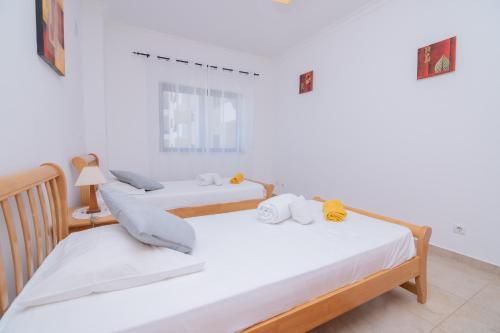 2 Betten in einem Zimmer mit weißen Wänden in der Unterkunft Palmeiras de jv in Lagos