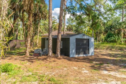 a small shed in the middle of some trees at Beautiful Home in Naples with Huge Private Pool in Naples
