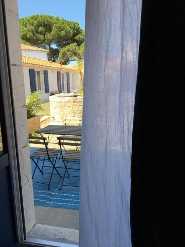 uitzicht op een patio met een tafel en een raam bij La possibilité d'une île in Boyardville