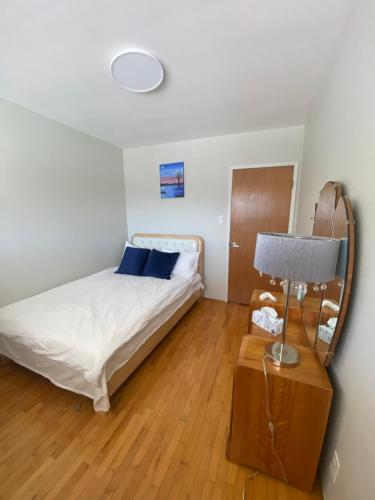 - une chambre avec un lit et une table avec une lampe dans l'établissement 佳佳便利民宿C, à Vancouver