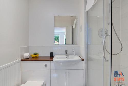 a white bathroom with a sink and a shower at OnSiteStays - Contemporary 2 Bed Apt with Ensuite, 2 x Free Parking Spaces & a Balcony in Dartford