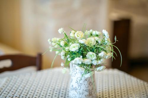 a white vase filled with white flowers on a table at Trulli di Nonno Carlo in Alberobello