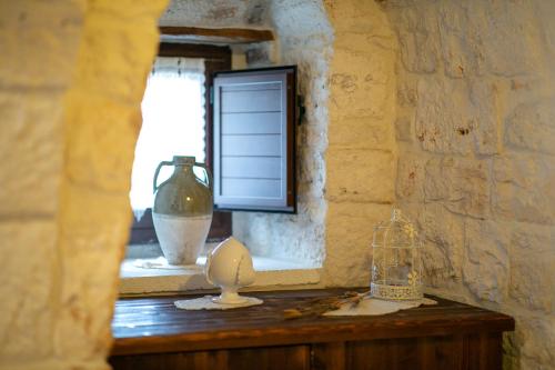 a room with a window and a table with a vase at Trulli di Nonno Carlo in Alberobello