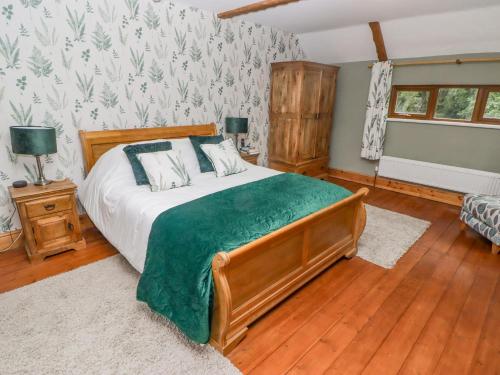 a bedroom with a large bed with a green blanket at Hafan Dawel in Llanfyrnach