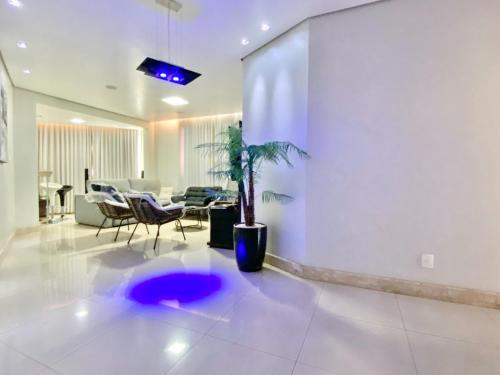 a living room with a potted plant on the floor at Portal do Jaragua in Belo Horizonte