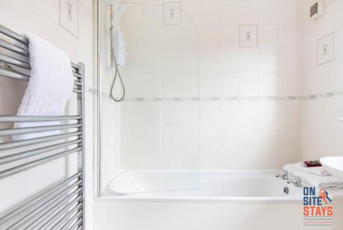 Baño blanco con bañera y lavamanos en OnSiteStays - Cosy 2-Bedroom Apartment with Private Entrance & Long Stay Prices, en Gravesend