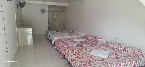 a room with three beds in a room at Hostal Makesa Tatacoa in Villavieja