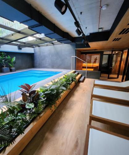 a swimming pool with plants and stairs in a building at Vistula loft apartment , free parking! in Kraków