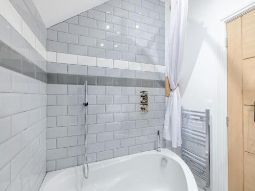 a white bath tub in a bathroom with white tiles at Eleni Loulou - Uk43585 in Ellesmere