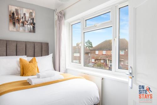1 dormitorio con cama y ventana en OnSiteStays - Cosy 2-Bedroom Apartment with Private Entrance & Long Stay Prices, en Gravesend
