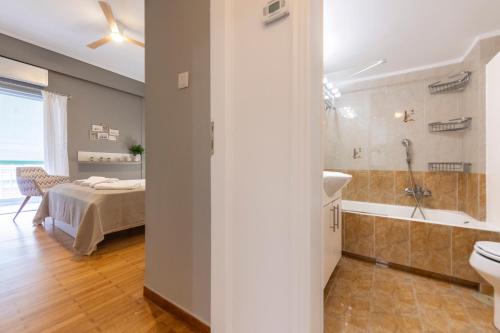 a bedroom with a bed and a bathroom with a sink at AinCAC Apartment Athens Center in Athens
