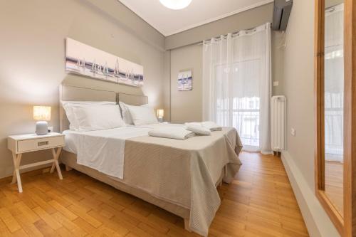 a bedroom with a large bed with white sheets at AinCAC Apartment Athens Center in Athens
