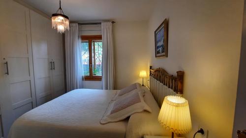 a bedroom with a bed and two lamps and a window at Aurea in La Losa