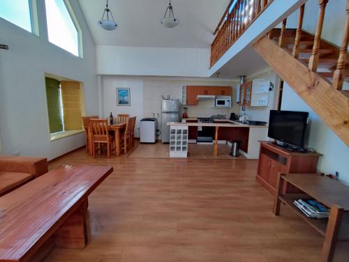 a living room with a kitchen and a dining room at Casas Isla Negra in El Quisco