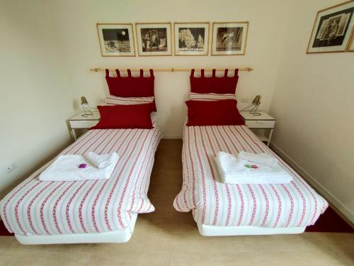 two beds in a room with red and white towels on them at Corte del Fuin - Dreaming Italy Travel in Seregno