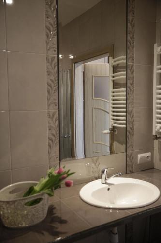 a bathroom with a sink and a mirror at Apartament MAJA Giżycko Żeglarska in Giżycko