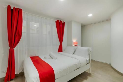 a bedroom with a white bed with red curtains at Superbe T3 proche Vieux-Port in Marseille