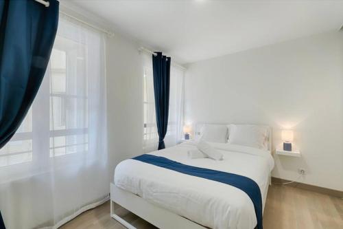 a white bedroom with a large bed and a window at Superbe T3 proche Vieux-Port in Marseille