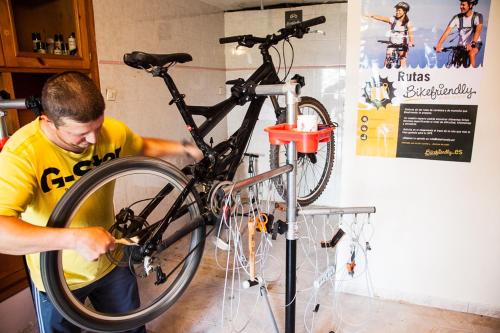 a man is holding a bike on a stand at Balcon del Pirineo Rural Ordesa in Buesa