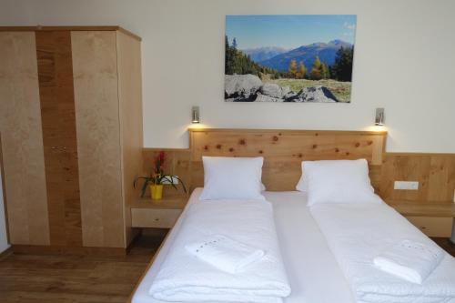 two beds in a room with a picture on the wall at Landhaus Dangl in Fliess