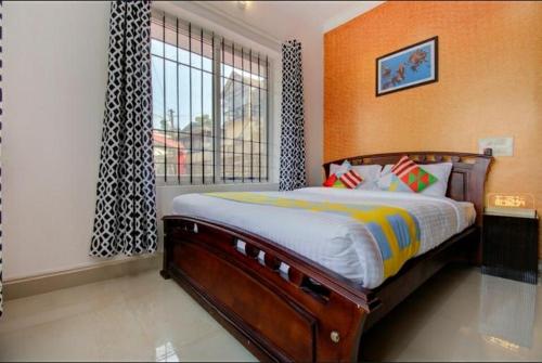 a bedroom with a large bed and a window at Coorg Vacation Stay(KKR) in Madikeri