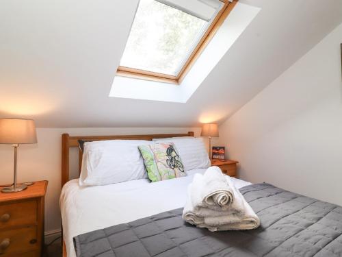a bedroom with a bed and a skylight at Cherry Tree Cottage in Windermere