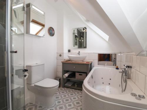 a bathroom with a toilet and a tub and a sink at Cherry Tree Cottage in Windermere