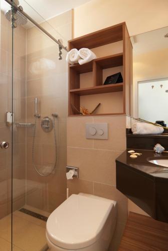 a bathroom with a shower and a toilet and a sink at Strandhotel Georgshöhe in Norderney
