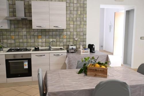 eine Küche mit einem Tisch und einer Schachtel Obst darauf in der Unterkunft White Oplonti House in Torre Annunziata