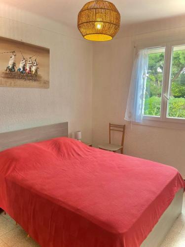 sypialnia z czerwonym łóżkiem i oknem w obiekcie Appartement T2 lumineux, moderne avec parking et wifi - 4SABLE16 w mieście Canet-en-Roussillon