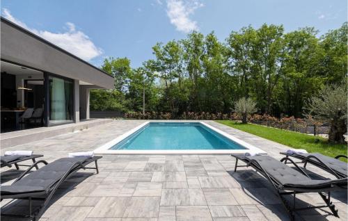 - une piscine avec 2 chaises longues et une maison dans l'établissement Villa Alison, à Ružići