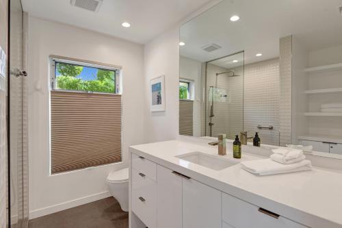 uma casa de banho branca com um lavatório e um WC em Trousdale Oasis- A tranquil and charming retreat, pool, spa, firepit, outdoor kitchen and more em Palm Springs