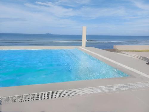 a swimming pool with a view of the ocean at TANA Beach Villas in Lian