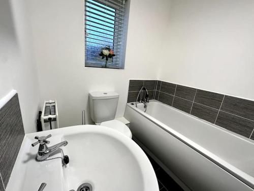 a bathroom with a tub and a toilet and a sink at Middlebeck House by Blue Skies Stays in Middlesbrough