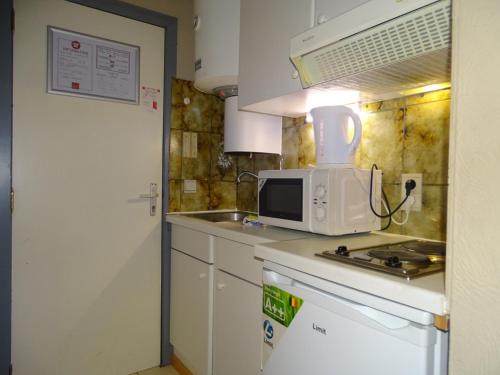 una cucina con forno a microonde sopra un bancone di Room in Studio - Condo Gardens Leuven - Budget Studio Single a Lovanio