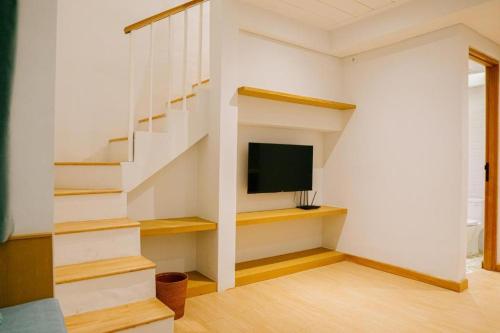 Pokój ze schodami z telewizorem i klatką schodową w obiekcie Casa Amarta - Canggu w mieście Canggu