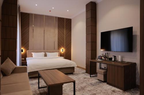 Habitación de hotel con cama y TV en DAMIR HOTEL, en Nukus
