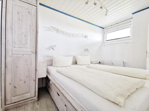 2 Betten in einem weißen Zimmer mit Fenster in der Unterkunft Haus Nordseeblick Nordseeblick, 1 in Norderney