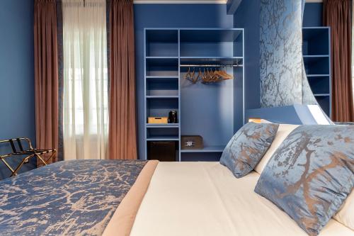 a bedroom with a large bed with blue walls at Le Texture Premium Rooms Duomo-Cordusio in Milan