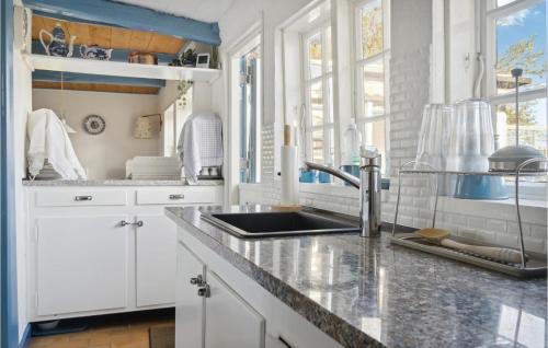 una cocina con armarios blancos y fregadero en Amazing Home In Horslunde With Kitchen en Horslunde