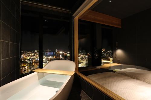 a bedroom with a view of a city at night at Hotel Nagasaki in Nagasaki