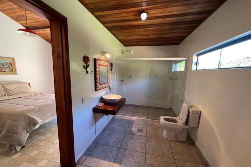 a bedroom with a bed and a bathroom with a toilet at Estância Village de Cunha in Cunha