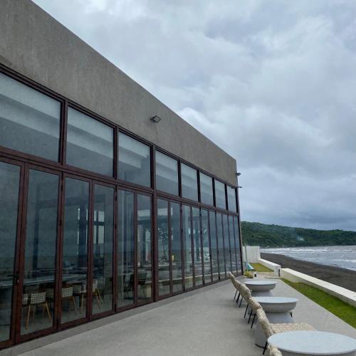 a building with benches in front of the ocean at TANA Beach Villas in Lian