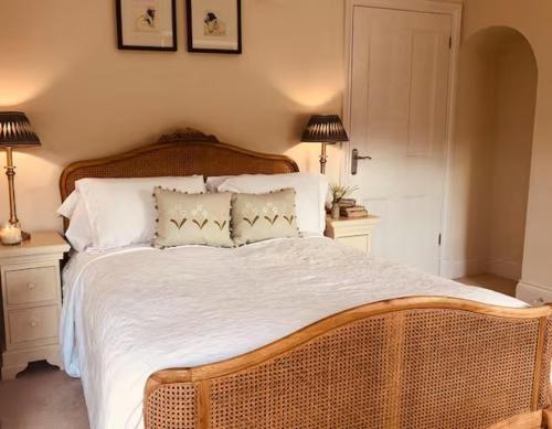 a bedroom with a large bed with white sheets and two lamps at Pass the Keys Old Beams Luxury Style & Comfort in Town Centre in Bakewell