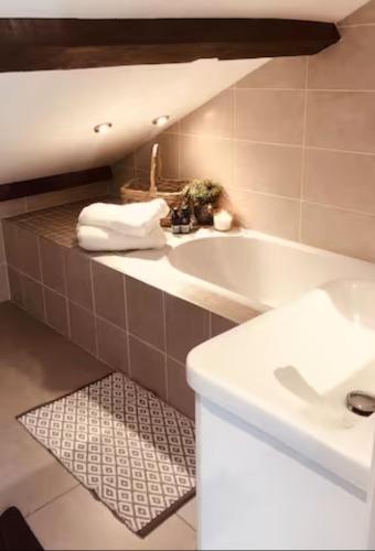 a bathroom with a white tub and a sink at Old Beams - Central Bakewell Stylish Duplex for 5 in Bakewell