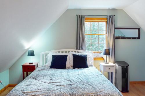 sypialnia z łóżkiem z niebieskimi ścianami i oknem w obiekcie Ellsworth Holiday w mieście Ellsworth