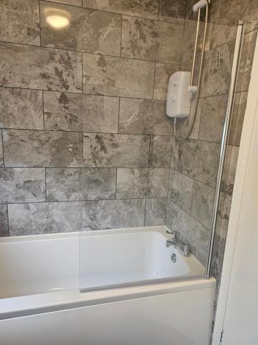 a bathroom with a bath tub and a shower at Hereford House - Welcome Short Stays in Derby